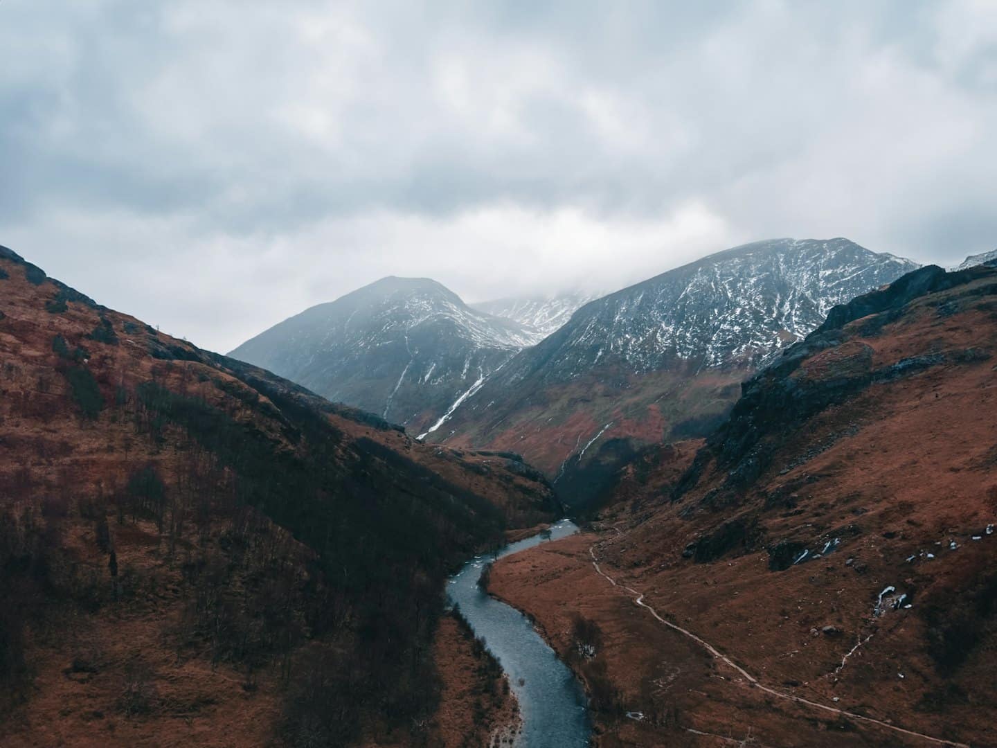 A winding river flows through a rugged mountain valley.